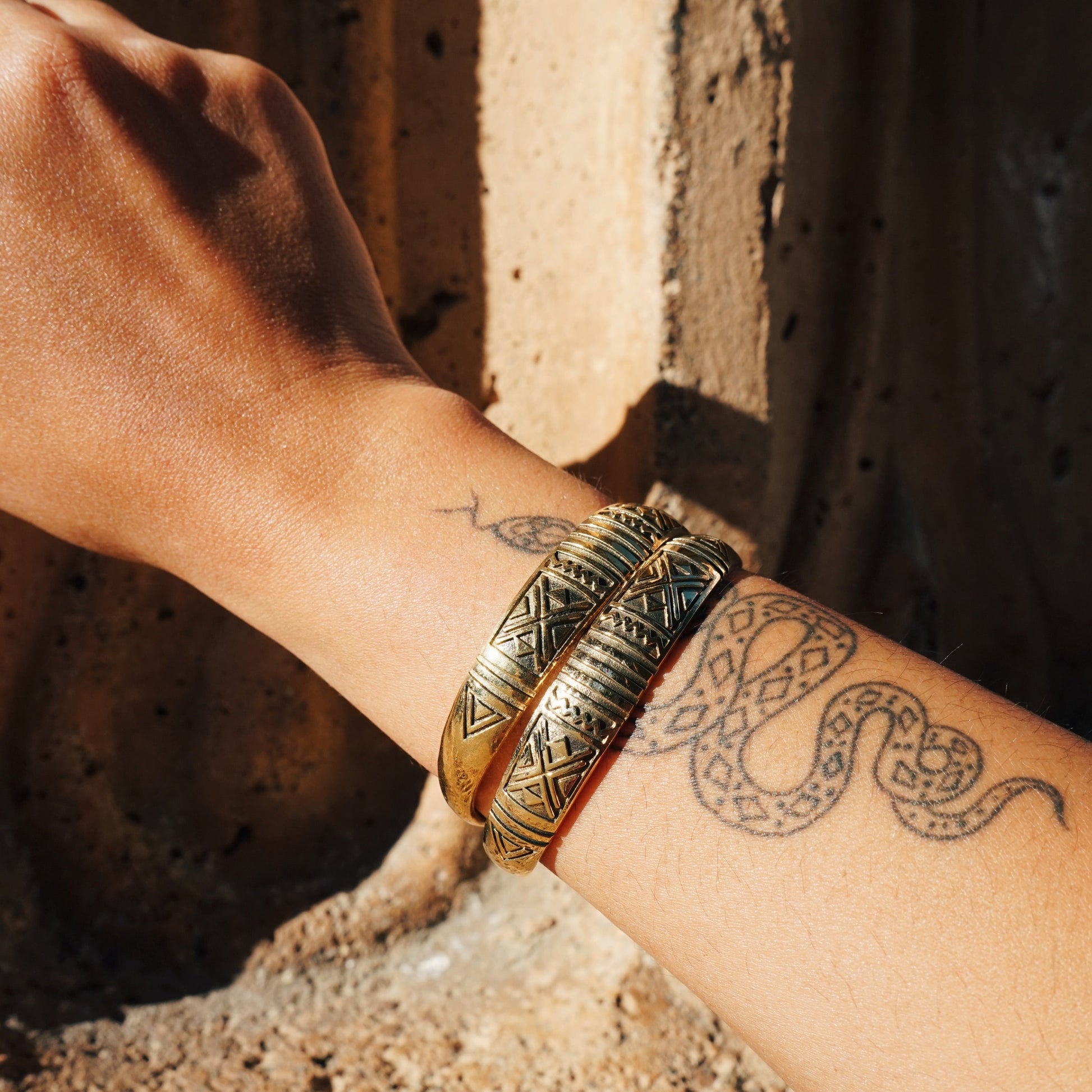 Brass Etched Cuffs on an arm with a snake tattoo